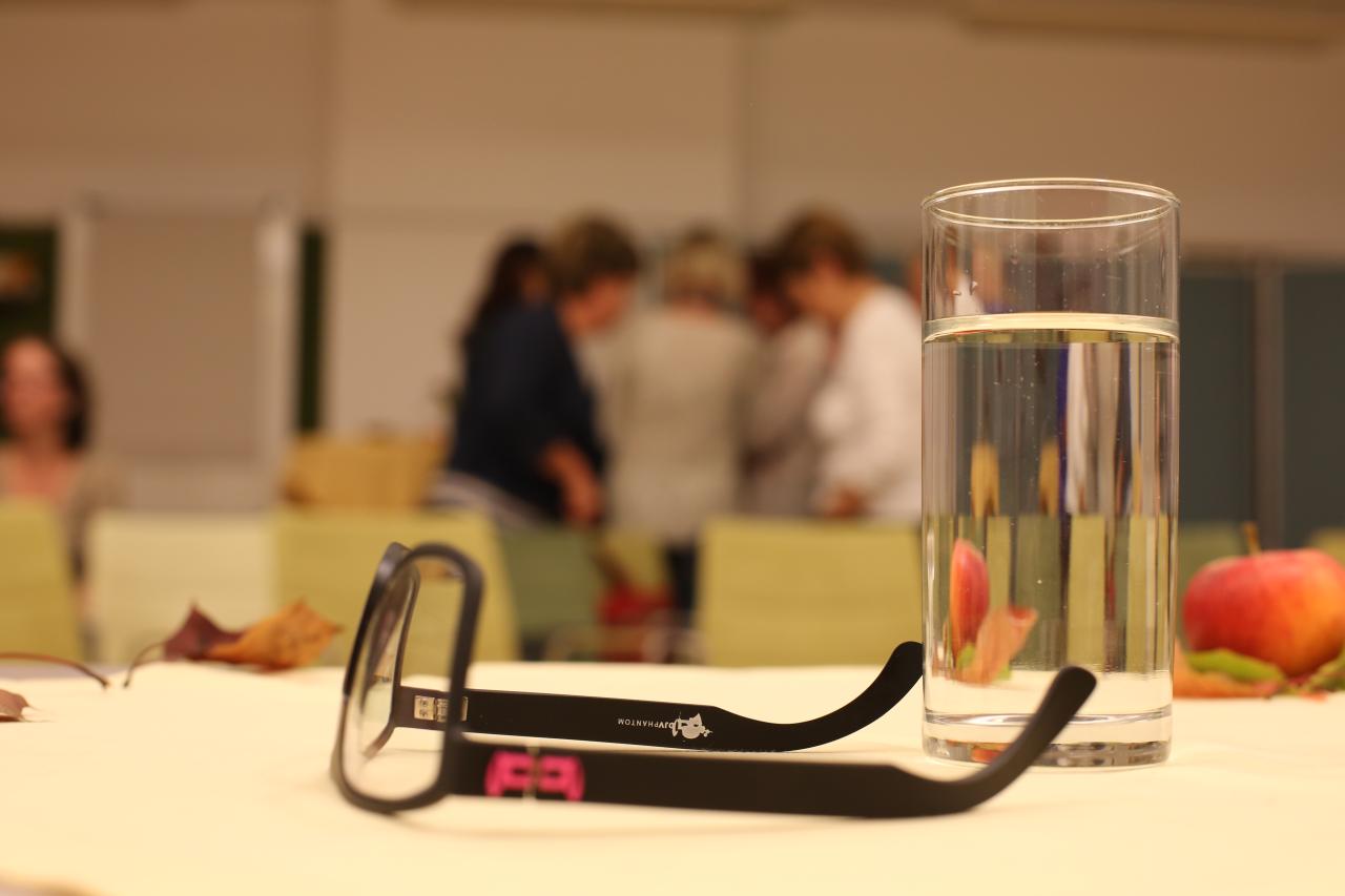 Am Tisch sind Lesebrille und Wasserglas